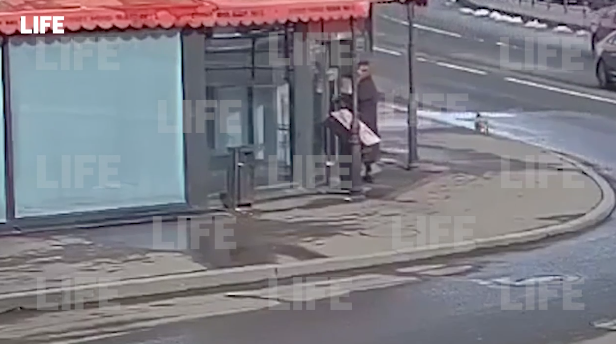 Подозреваемая в организации взрыва входит в петербургское кафе. Кадр видео © LIFE