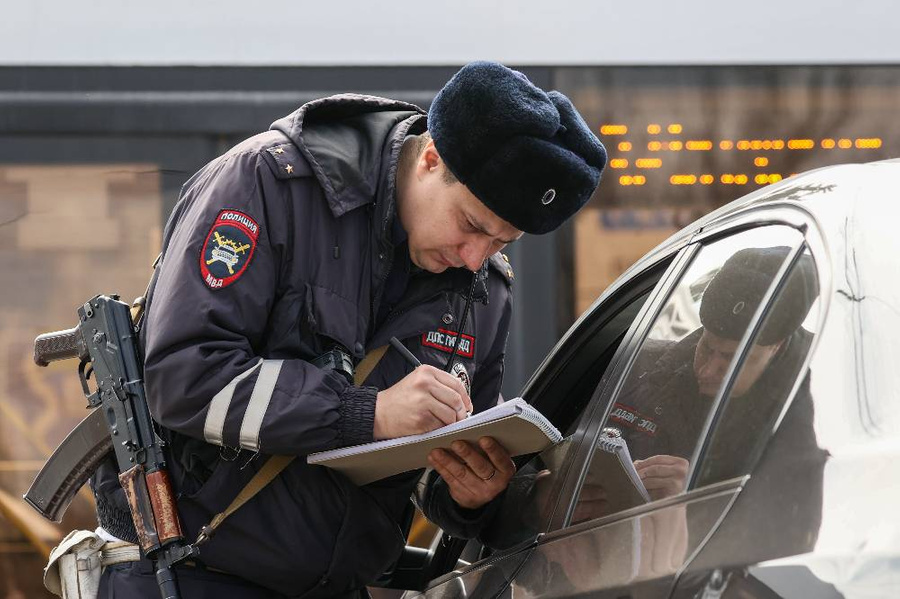 Сотрудник ГИБДД оформляет протокол за нарушение ПДД. Фото © ТАСС / Сергей Мальгавко