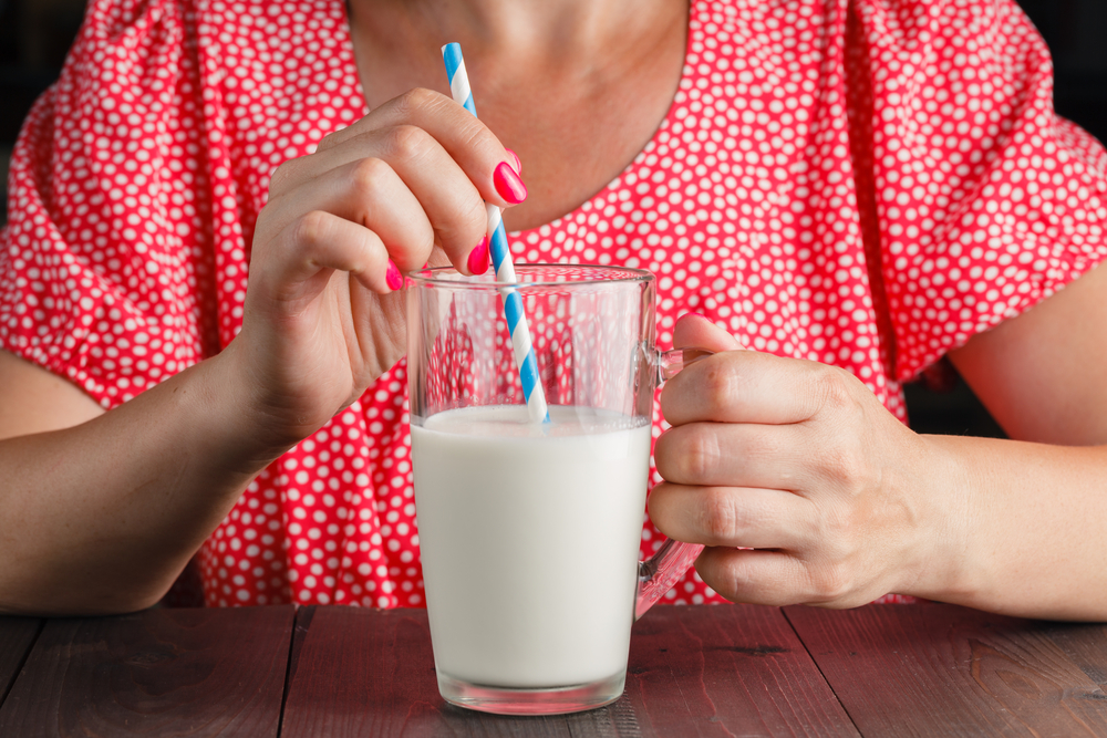 She drink milk. Молоко фотосток. Девушка с молоком. Пьет молоко. Молоко в руке.