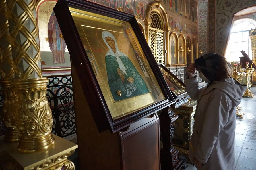 Женщина перед иконой блаженной Матроны Московской. Фото © ТАСС / Александр Артеменков