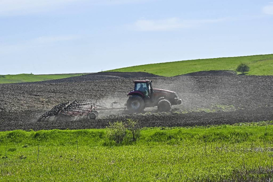 Трактор обрабатывает землю перед посевом в поле у украинско-российской границы на Украине. Фото © Getty Images / Anadolu Agency