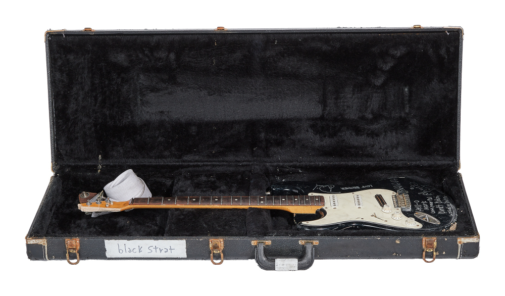 Разбитая гитара Курта Кобейна в чёрном чехле с ремешком. Фото © Julien's Auctions