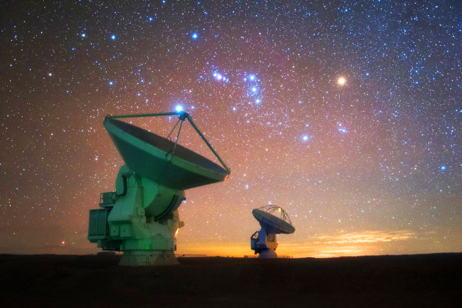 Две из 66 антенн ALMA, над которыми висит созвездие Орион, справа видна красная звезда-сверхгигант Бетельгейзе. Обложка © Flickr / European Southern Observatory