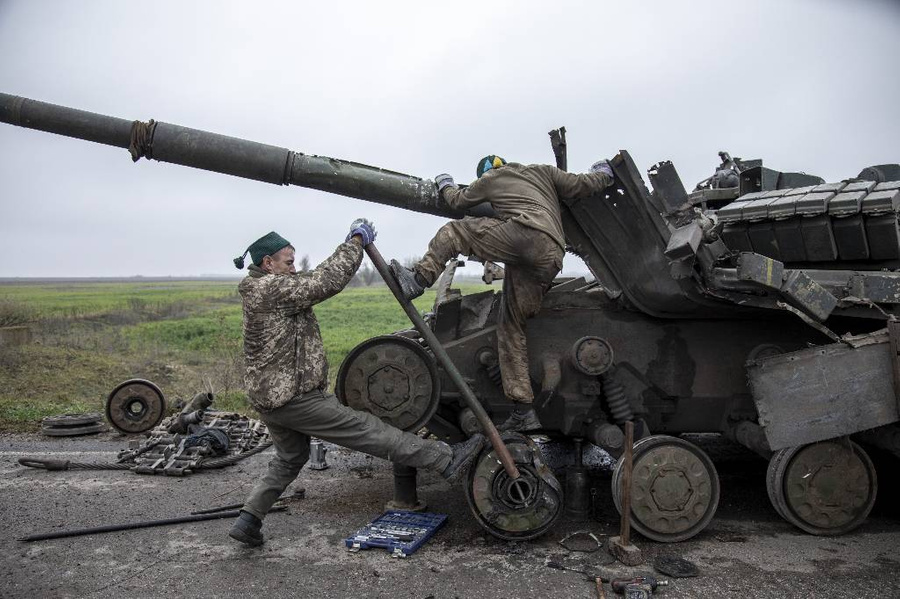 Украинские военнослужащие разбирают разбитый танк. Фото © Getty Images / Anadolu Agency