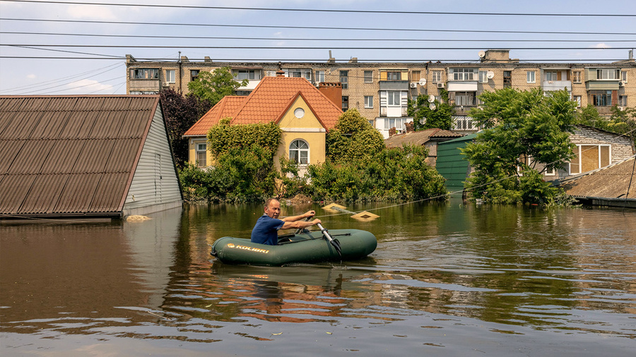 <p>Мужчина в надувной лодке на затопленной улице Херсона. Обложка © Getty Images / Roman Pilipey</p>