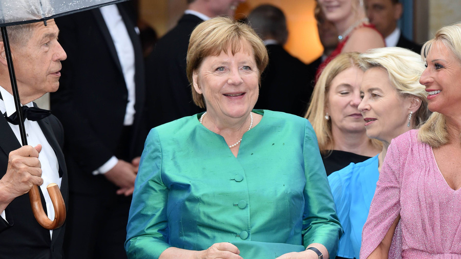 Иоахим Зауэр и его мокнущая под дождём супруга Ангела Меркель. Обложке © Getty Images / Tristar Media