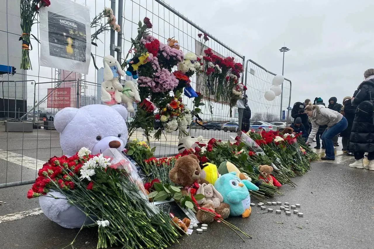 Люди несут цветы и игрушки к мемориалу у Крокуса на 40-й день после теракта