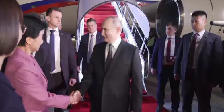 В Харбине Путина встретили красной дорожной и долгими рукопожатиями