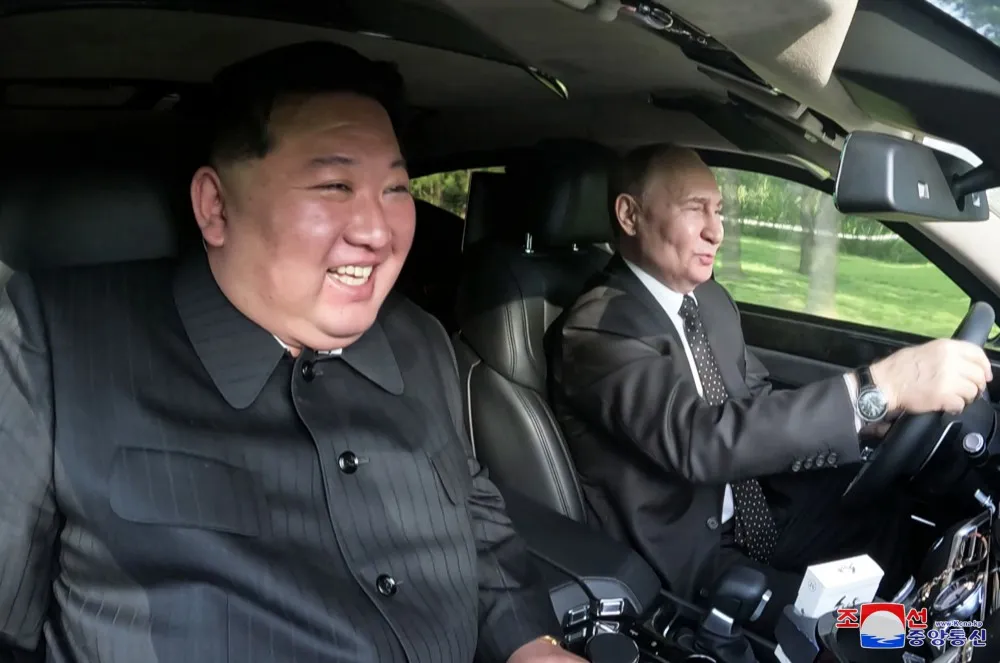 В КНДР показали фото Путина и Ким Чен Ына в салоне Aurus и во время прогулки в саду с собаками