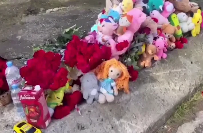 Люди несут цветы и игрушки к стихийному мемориалу у дома в Нижнем Тагиле