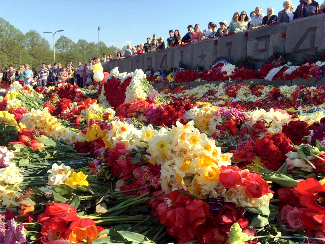 В Риге жители несут цветы к памятнику советским солдатам в День Победы